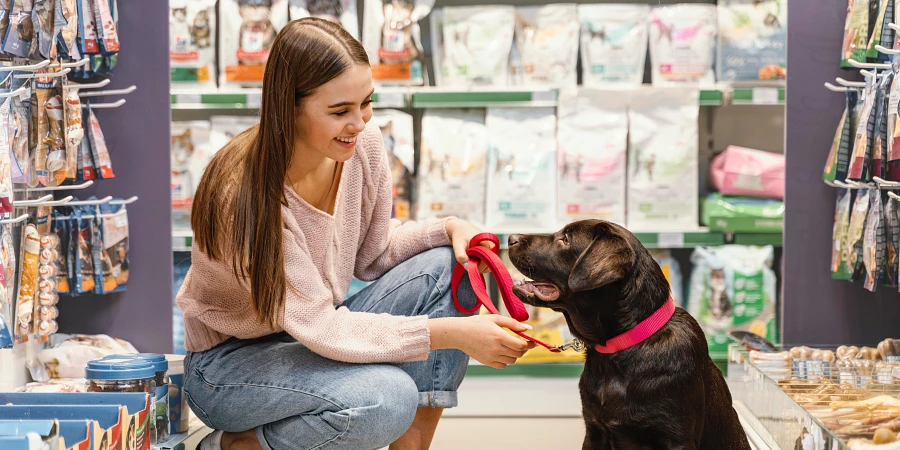 Adorable perro con dueña en tienda de mascotas