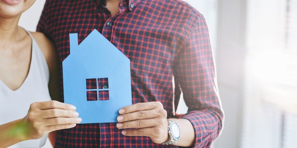 Pareja sosteniendo figura de casa nueva