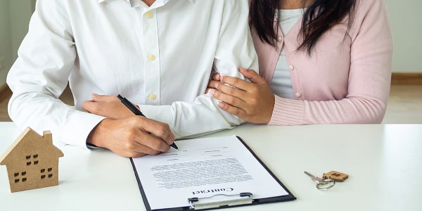 Pareja firmando contrato de crédito hipotecario para casa nueva